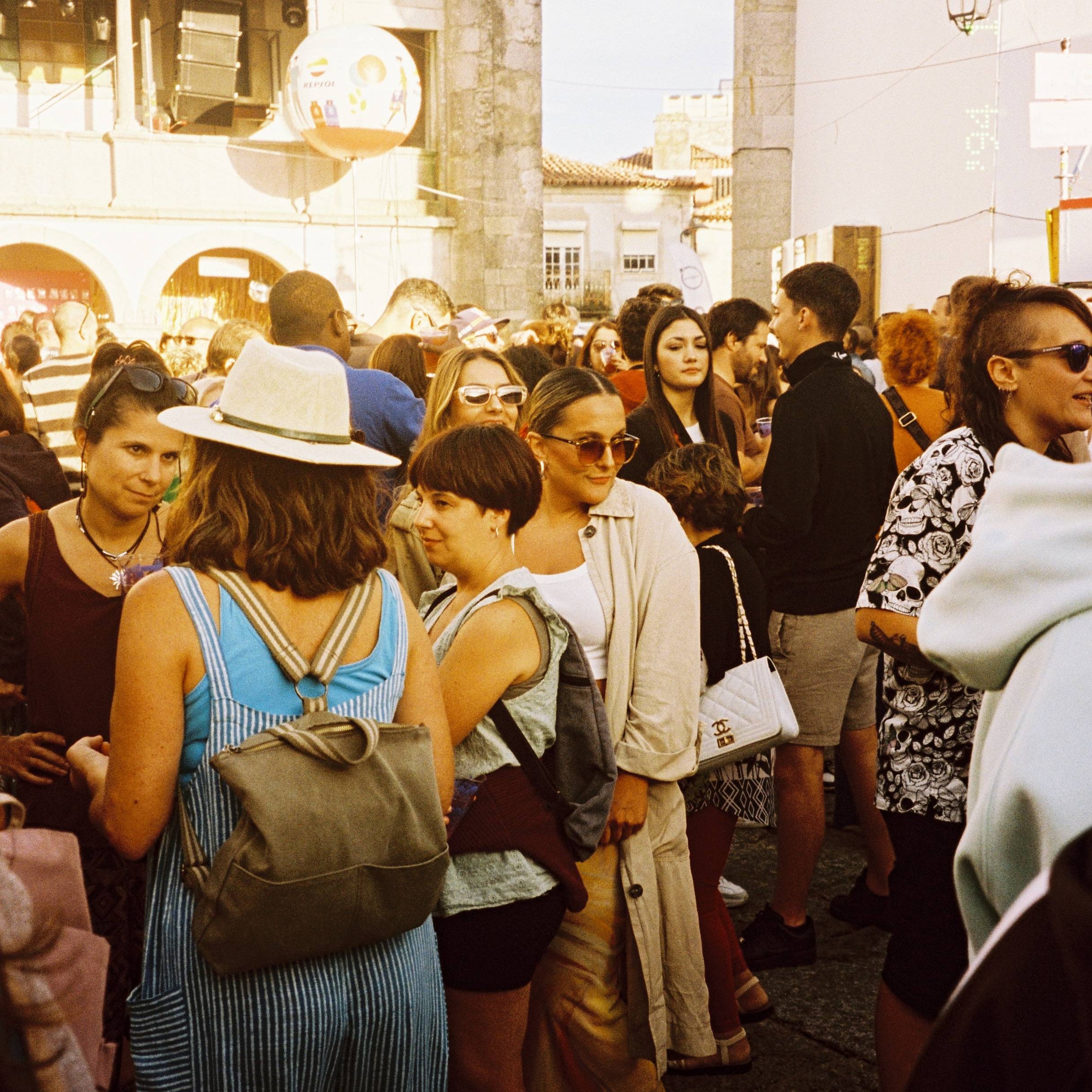 Crowd of people in a city street with architectural elements in the background