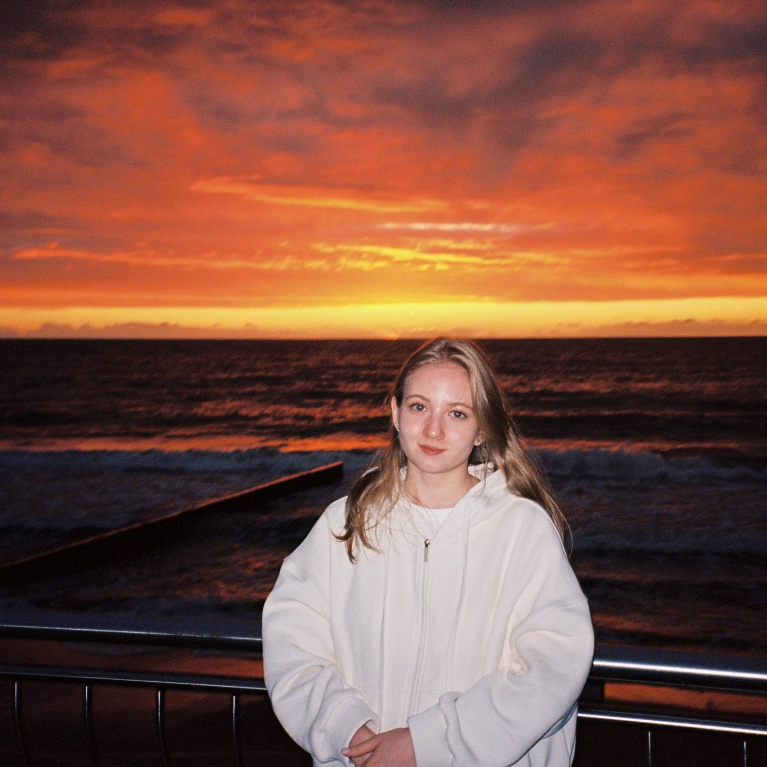 Girl standing in front of sunset