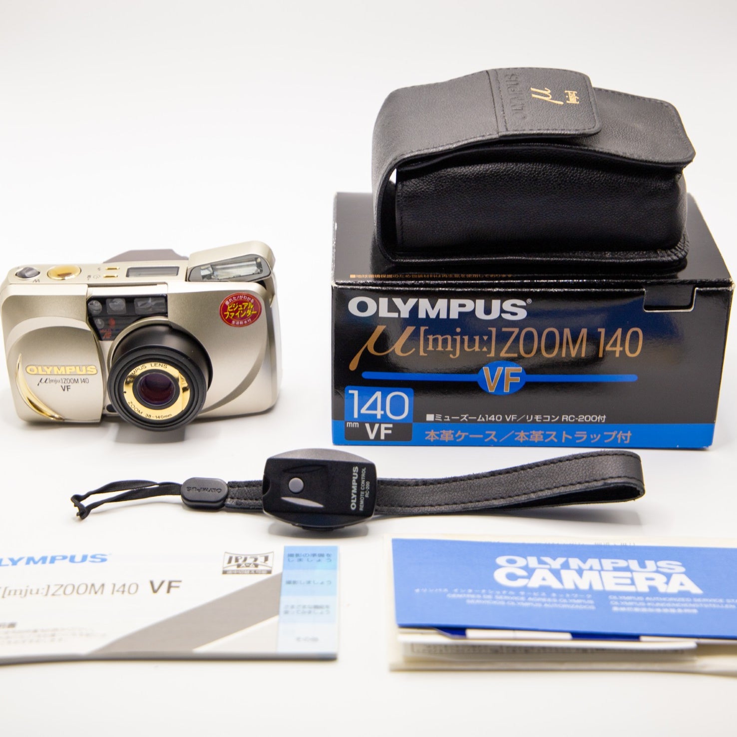 Olympus camera with packaging and accessories on a white background