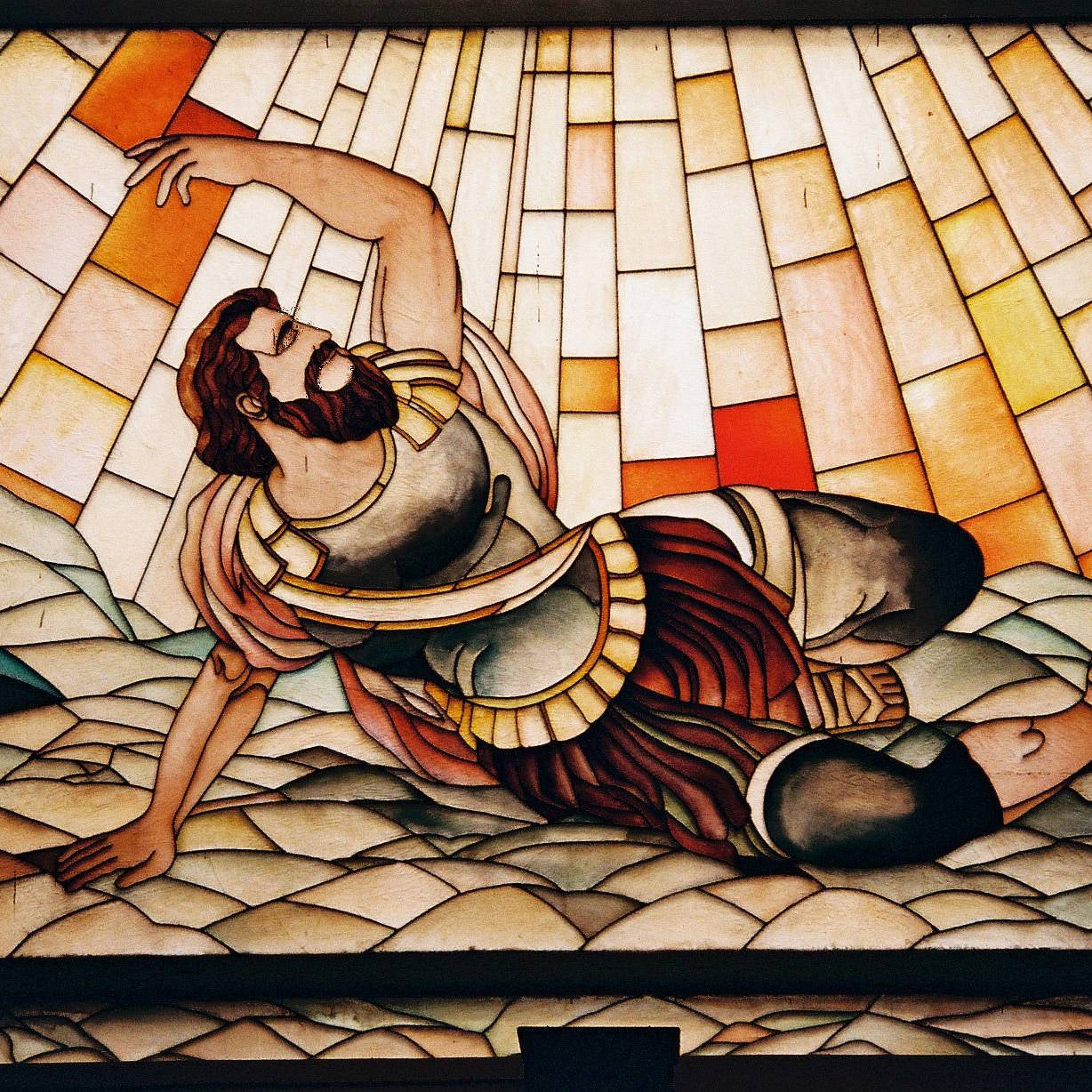 Stained glass panel depicting a person in classical attire on a textured background