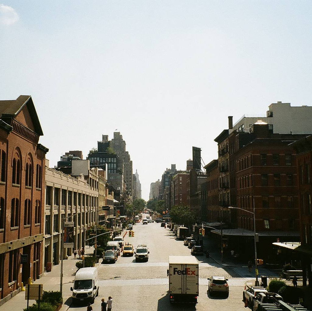 New York city street with brick buildings and vehicles on a sunny day