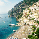 Scenic view of a coastal town with buildings built into a cliffside overlooking the sea.