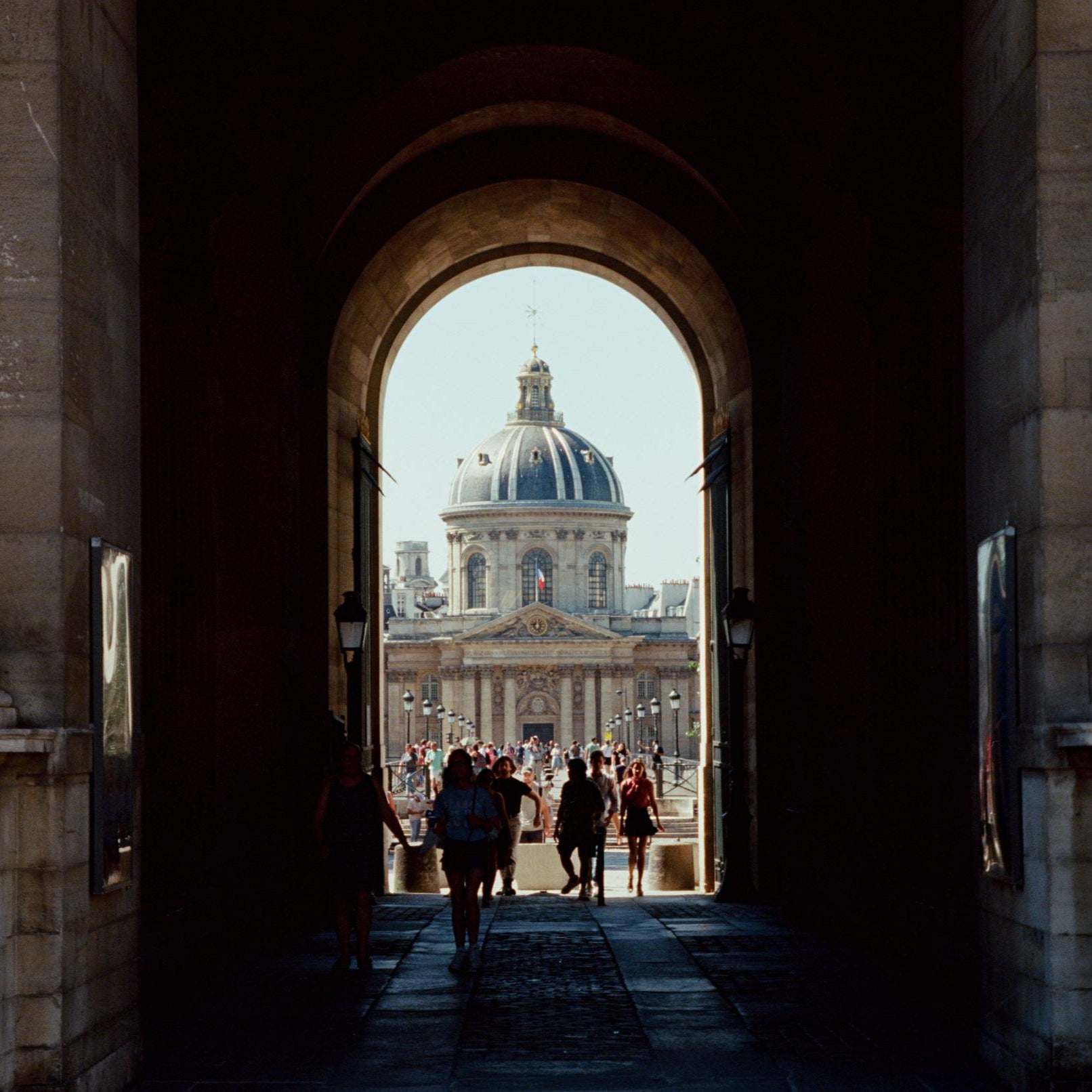 Archway leading to a domed building with people walking inside