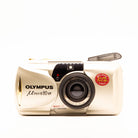 a photo of a vintage olympus gold point-and-shoot film camera